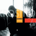 Charles de Goalin tribuuttialbumin "Exposition" etukannessa valokuva sohvalla istuvasta miehestä. Taustalla valkoisena hohtava ikkuna ja lattia shakkikuvioitu. Kuvaa halkoo osittain läpinäkyvät raidat, palkit ja kirjaimet.