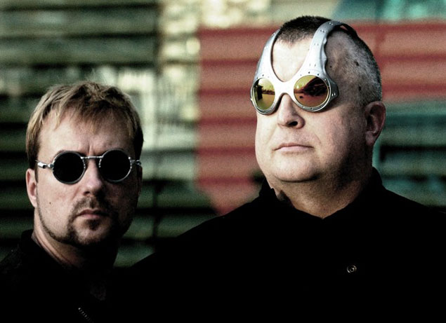 Valokuva kahdesta Novakillin jäsenestä, jotka ovat mustiin pukeutuneita miehiä. Vasemman laidan hepulla mustat aurinkolasit, oikean laidan harmaahapsuisella miehellä futuristiset metallisankaiset aurinkolasit, joiden sangat kulkevat kallon päältä,