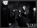Tummasävyinen valokuva goottibändi The Coldin viidestä miesjäsenestä, jotka seisovat tummassa holvimaisessa tilassa mustiin pukeutuneina.
