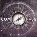 Assemblage 23:n albumin "Compass" etukannessa sana Compass valkoisella värillä ja kuvan keskellä näkyy yksityiskohtainen kuva kompassista, joka on upotettu jonkinlaiseen harmaaseen kivileikkaukseen.