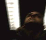 Portion Controlin albumin "Violently Alive" etukannessa näkyy epätarkka valokuva miehen kasvoista kuvattuna alhaalta ylöspäin. Miehen kasvojen takana näkyy katossa loistavia halogeenilamppuja.