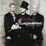 Oomph!-yhtyeen jäsenet synkässä valokuvassa seisomassa vaalean kiviseinän edustalla. Kuvan jäsenistä kaikki ovat miehiä ja heillä mustat vaatteet. Keskimmäisellä miehellä silinterihattu päässä.