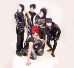 Tragic Black -bändin promokuva. Miehet seisovat yhdessä kukin pukeutuneina miten sattuu. Ympärillä haaleanpunaista väriä.