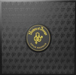 "Opus Magnus" -albumin etukannessa harmaa hillitty kuvioitni, jonka keskellä pyöreä kohokuvio, jossa keltaisella värillä lukee Umbra Et Imago ja albumin nimi.