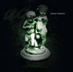 Musta pohjaväri ja sen keskellä hämärä, vihertävä valokuva patsaasta. Patsaassa kaksi alastonta lasta hyppii ja leikkii.