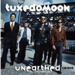 "Unearthed"-albumin etukannessa valokuva 1970-luvun tyyliin pukeutuneista miehistä, joiden yläpuolella lukee valkoisella Tuxedmoon ja alaosassa samaan tyyliin "Unearthed".