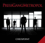 Valokuva suuresta valottomasta salista, jonka taustalla olevasta seinästä lankeaa valoa ihmisten takaa.