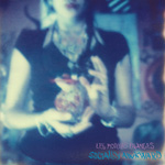 Sinisävyinen, epätarkka valokuva ihmisestä, jolla musta lyhythihainen paita ja jonkinlainen sydämenmuotoinen esine hyppysissään.