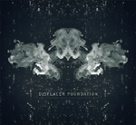 Tummansininen, lähes harmaa, tausta, jota vasten abstrakteja tahroja Rorschachin tyyliin.