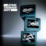 Atari Teenage Riot -logo vasemmassa yläkulmassa valkoisella värillä. Kuvassa kolme sinistä laatikkoa harmaata taustaa vasten.