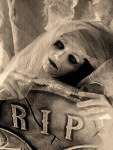 Zombie Girl -bändin Renee poseeraa ruumiiksi maskeerattuna valkoisen hunnun alla. Edessä jonkinlainen kyltti tai laatta, jossa lukee "RIP".