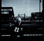 Suicide Inside -bändin Natasha seisoo jonkinlaisen kävelytien varressa, jonka takana on leveähkö autotie, jonka takana taas silta. Naisella lyhyet vaaleat hiukset sekä yllään musta paita, jossa etuosassa lukee "21".