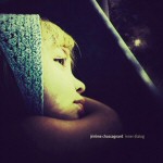 Vanha valokuva pikkulapsesta, jolla sininen myssy päässä ja joka katselee väsyneesti eteensä.