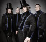 Down Below -yhtyeen jäsenet, eli neljä miestä, seisoo rivissä pukeutuneena samanlaisiin takkeihin ja housuihin. Kahdella miehellä päässään korkea, mustanvärinen silinteri.