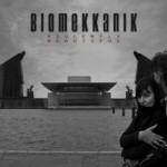 Harmaasävyinen valokuva suuresta aukiosta, jonka keskellä temppeli tai palatsi. Yläosassa taivasta vasten Biomekkanik-logo mustalla.