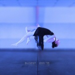 Sinistä taustaa vasten, sinisen lattian päällä, levitoiva ballerina.