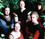 Islantilaisen Wolfenmond-bändin jäsenet seisovat vihreiden lehtien ympäröimänä. Kuvassa viisi miestä ja yksi nainen. Heillä yllään kansallispuvut tai muut samantyyliset vanhahtavat asusteet.