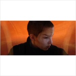 Valkoista taustaa vasten valokuva sukupuolettomasta ihmishahmosta, jolla lyhyt tukka ja joka katsoo sivulleen.