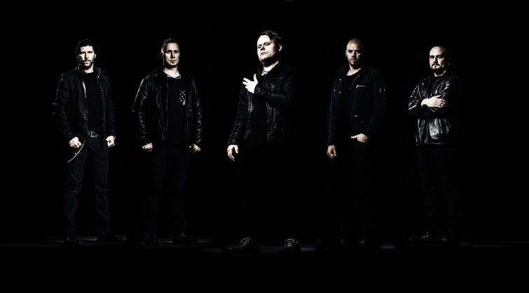 Valokuva viidestä miehestä mustiin pukeutuneena mustaa taustaa vasten.