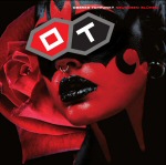 Valokuva punamustiksi maalatuista naisen kasvoista, joissa silmien päälle laitetut kulmikkaat lasit. Niissä lukee OT.