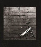 Mustien reunaviivojen sisällä harmaasävyinen valokuva leystä, jossa nauloja, ruuveja ja jokin teräksinen työkalu.