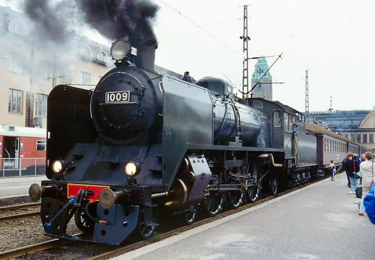 Valokuva höyryveturista, jonka nokassa on numero 1009. Veturista tulee mustaa savua.