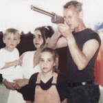 Värivalokuva miehestä, jonka vieressä kaksi nuorta lasta ja keskimmäisenä tummahiuksinen nainen.