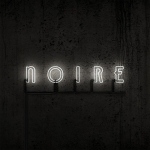 Mustaa taustaa vasten valkoisella värillä "Noire"-sana ilman lainausmerkkejä.