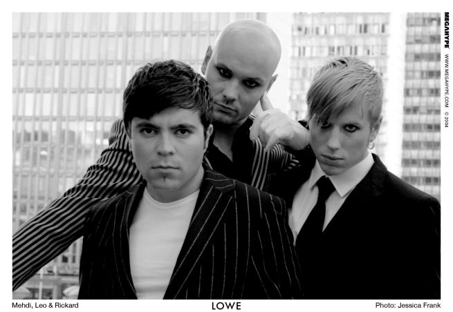 Mustavalkoinen ryhmäpotretti kolmesta Lowe-bändin miehestä. Jokaisella heistä lyhyet hiukset, paitsi keskimmäinen on kalju. Kolmikolla tummat puvut yllään, kahdella vasemmanpuoleisella vahvaa liituraitaa pukupaitansa kuviointina.