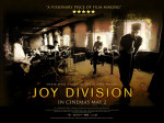 Joy Divisionin dokumenttielokuvan, nimeltään "Joy Division", flaijeri, jossa näkyy bändin jäsenet soittamassa musiikkia suuressa pitkänomaisessa huoneessa tai salissa. Kuva on hämärä, varjostettu mustalla värillä laidoista. Keskellä kuvaa suur