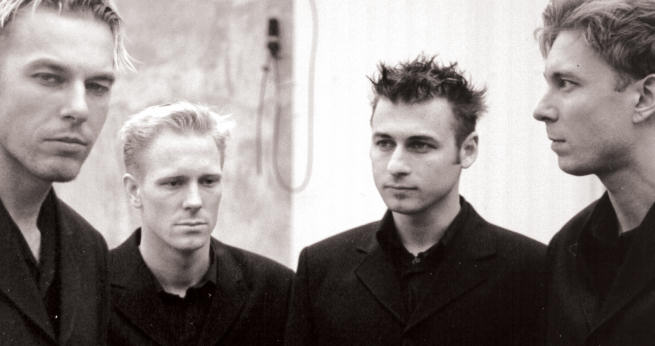 Harmaasävyinen valokuva Kiethevez-bändistä Jakob Hammarskjöldin ottamassa pressipotretissa. Kuvassa neljä mustiin pukeutunutta miestä. Jokaisella vakavat ilmeet kasvoillaan. He seisovat rivissä vaaleata taustaa vasten. Kaikilla lyhyt hiukset, joiss