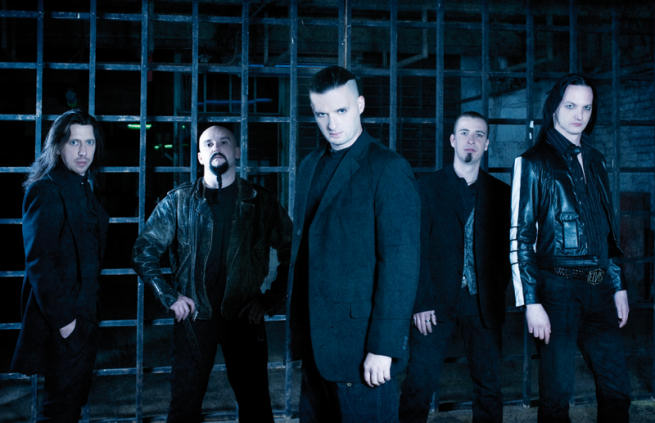 Viisi mustiin pukeutunutta mieshenkilöä seisovat rivissä ulkoilmassa. Valokuva sävyltään synkkä, kylmänsininen. Kuvassa olevat ihmiset ovat miehiä, joista osalla viikset ja partaa, pitkät hiukset. Taustalla suuri takorautainen portti.